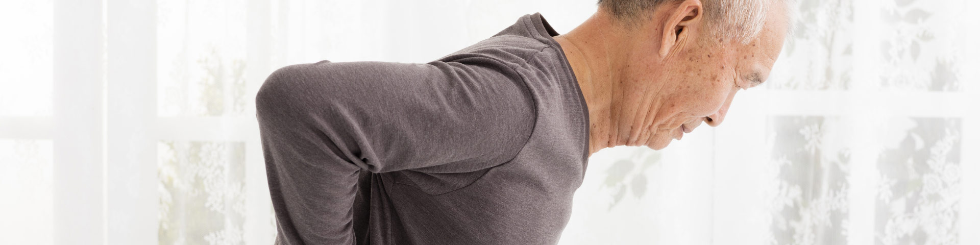 Man suffering from lumbar spinal stenosis (LSS) pain