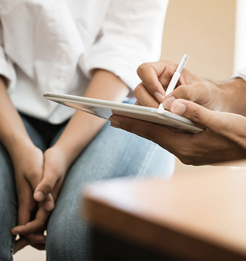 Physician taking notes while speaking with an LSS patient