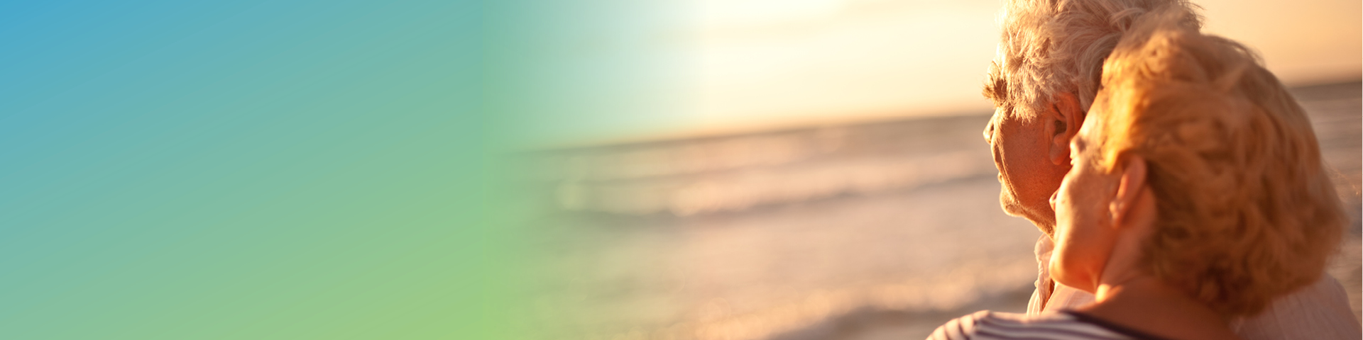 Older man and older woman looking into the sunset.